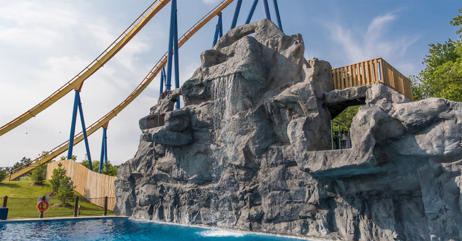The Betz-built pool at Canada's Wonderland, with its cast rock waterfall feature and the Behemoth roller coaster behind it.
